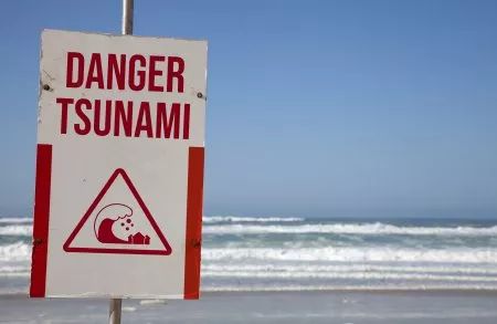 a sign warning people to stay out of the water and not enter this beach area