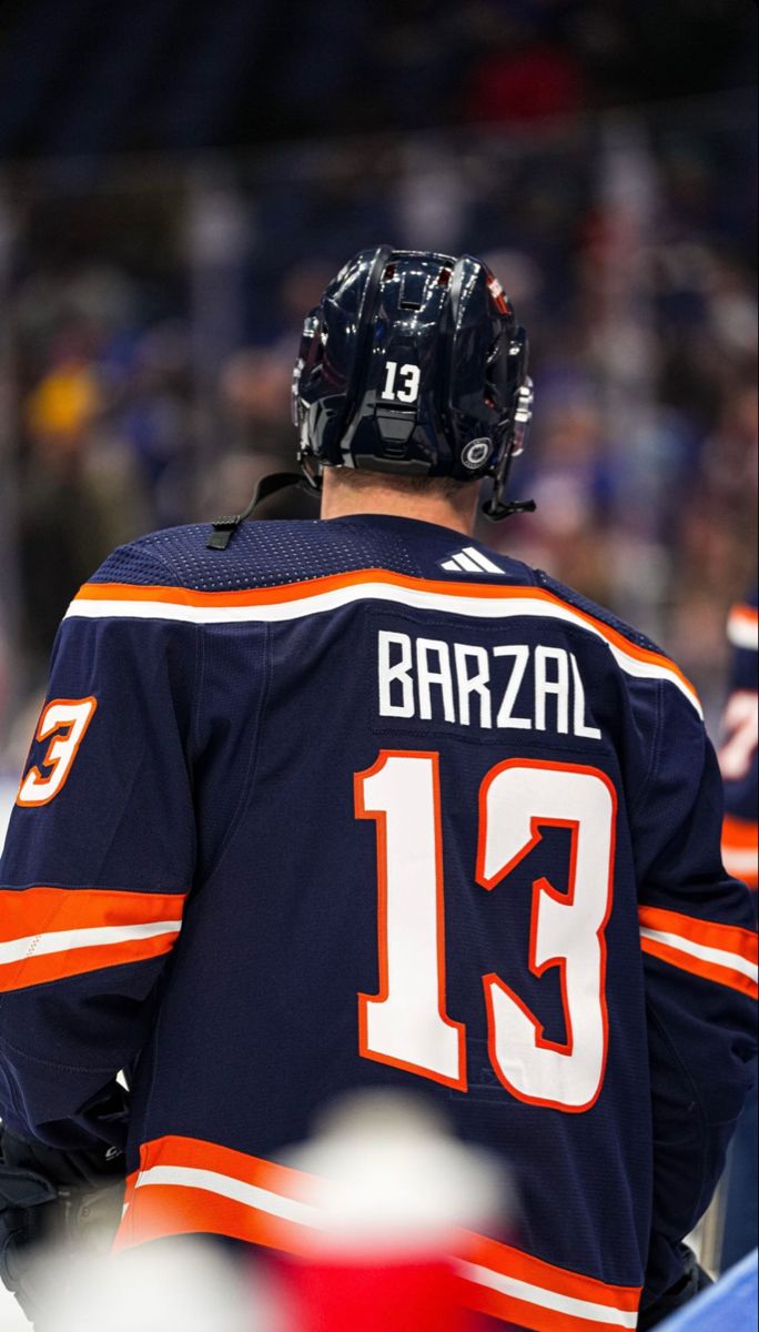 a hockey player wearing an orange and blue jersey