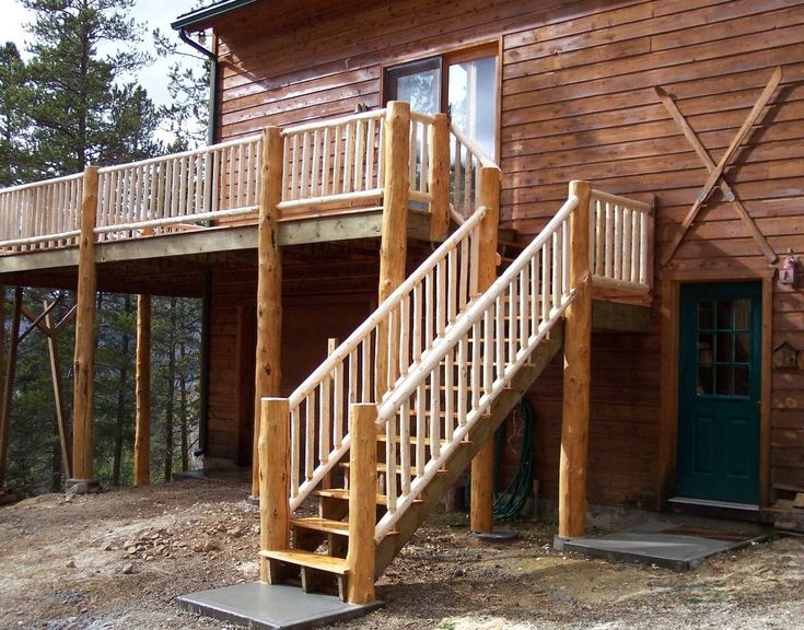 a wooden house with stairs leading up to the front door