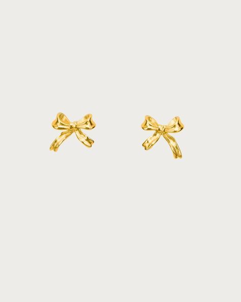 Graced with an enchanting bow motif, these earrings exude the charm and elegance of balletcore aesthetics. Perfect for daily wear, these earrings blend the poise of ballet with a playful, festive spirit, making them an ideal accessory for those who adore a touch of whimsy in their style. Materials: 18k gold plated brass / Platinum plated brass Measurements: 9.35mm/0.37" in width, 7.48mm/0.29" in height Preppy Earrings Classy, Fancy Earrings Gold, Earing Stack Gold, Earrings Aesthetic Gold, Gold Bow Jewelry, Gold Dainty Earrings With Bow, Cute Gold Earrings, Bow Gold Earrings, Bow Earrings Gold