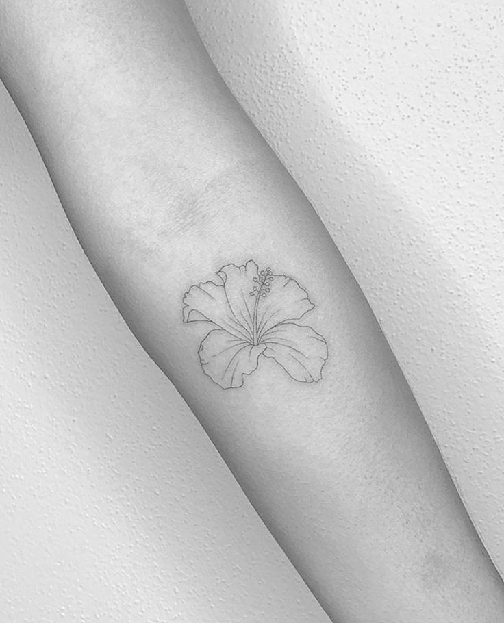 a single flower tattoo on the arm