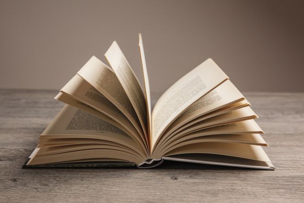 an open book sitting on top of a wooden table