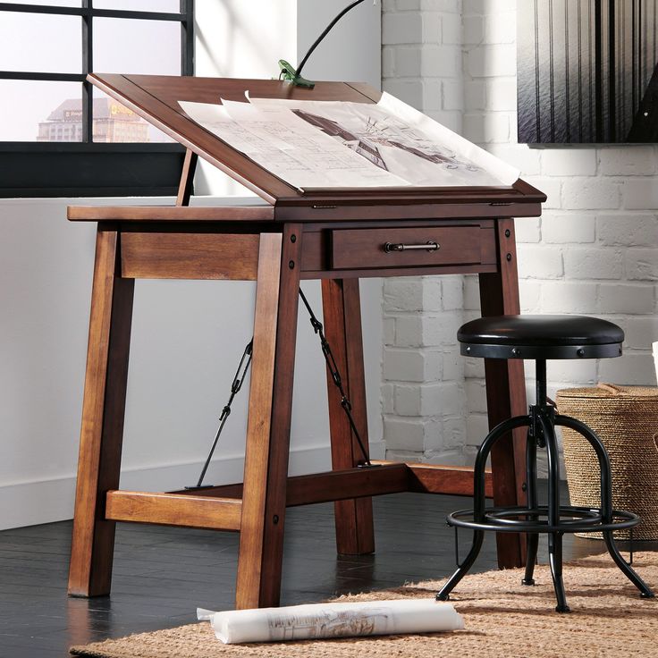 a wooden easel sitting on top of a hard wood floor next to a window