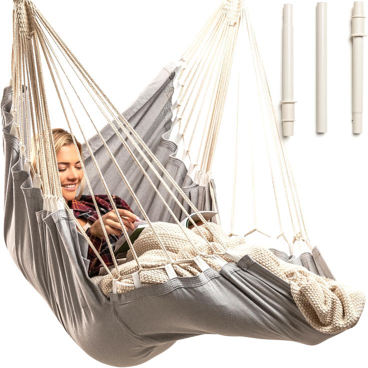 a woman is sitting in a hammock and smiling