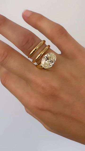 a woman's hand with two rings on it and a diamond in the middle