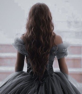 a woman in a black dress looking out the window