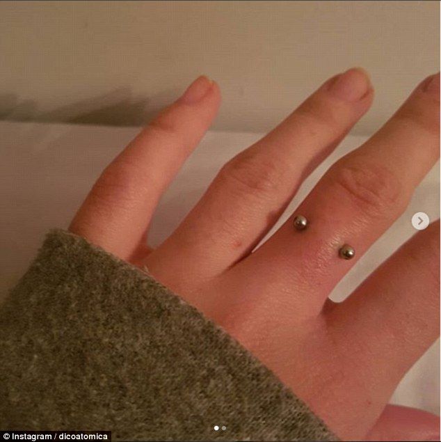 a person's hand with two small rings on their fingers and one ring is in the shape of a heart