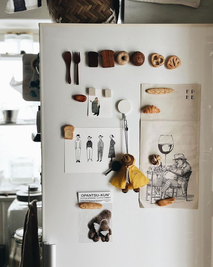 a white refrigerator with magnets and pictures on the front, along with other kitchen utensils