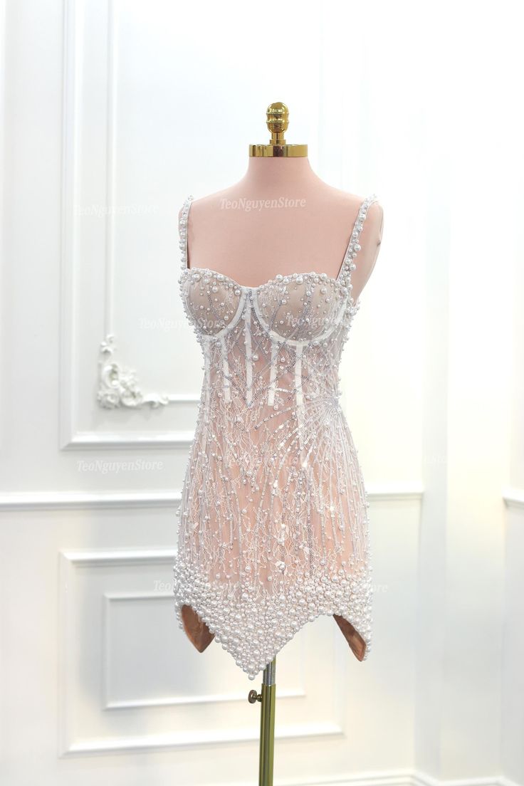 a mannequin wearing a white beaded dress