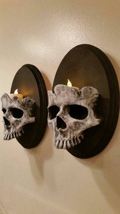 two skulls are mounted to the wall with candles