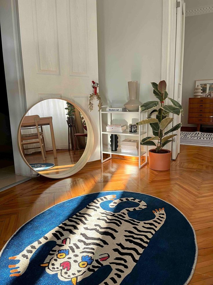 a blue rug with a tiger on it in front of a mirror and chair next to a potted plant