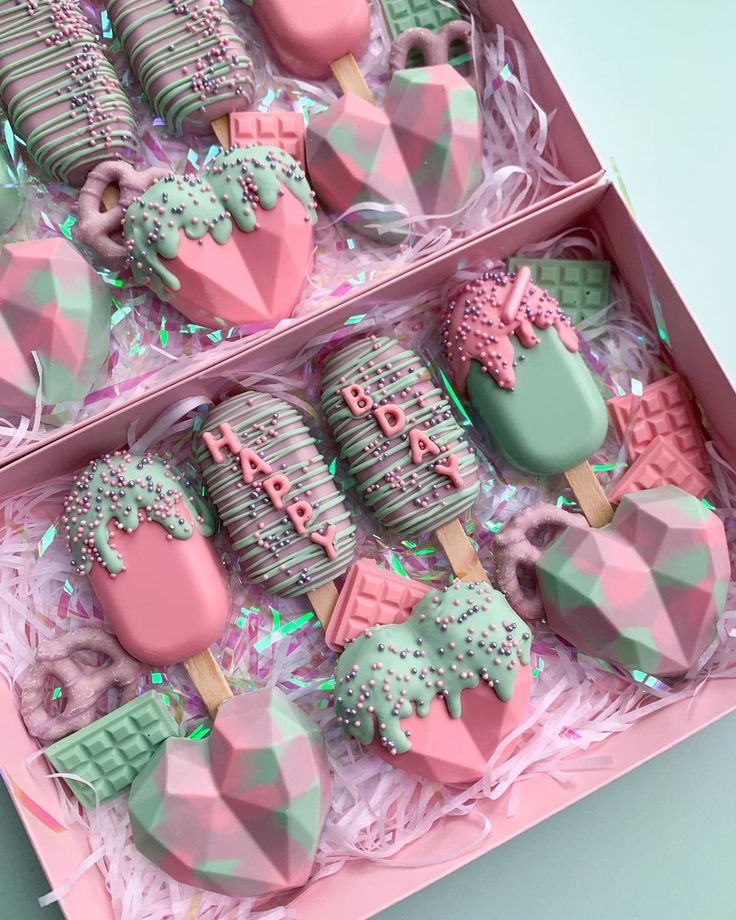 pink and green decorated cookies in a box