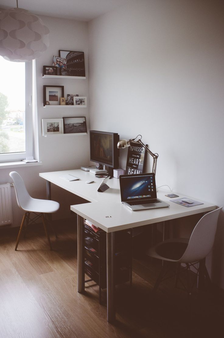 a desk with a laptop computer on top of it next to a chair and window