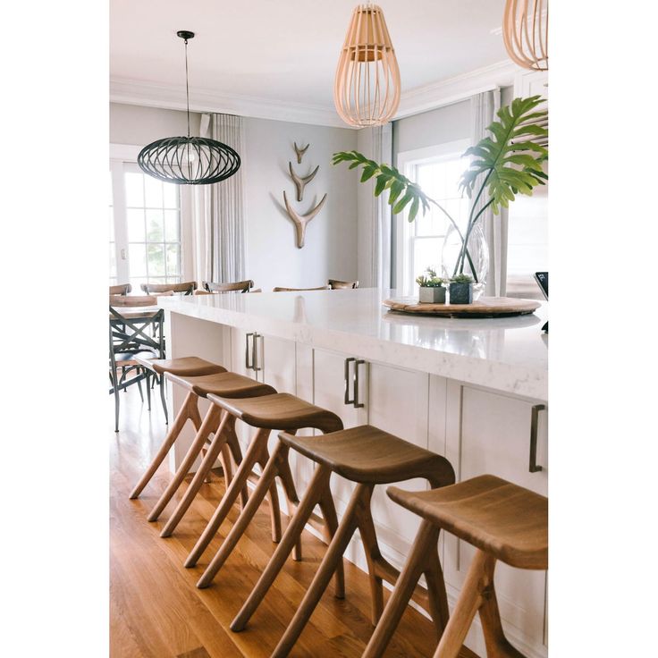 a kitchen filled with lots of counter top space and wooden stools next to it