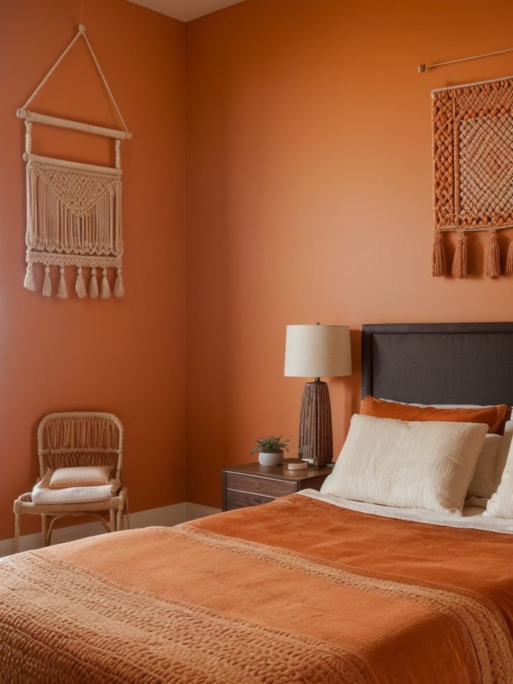 a bedroom with an orange wall and bed in the corner, two wicker chairs on either side