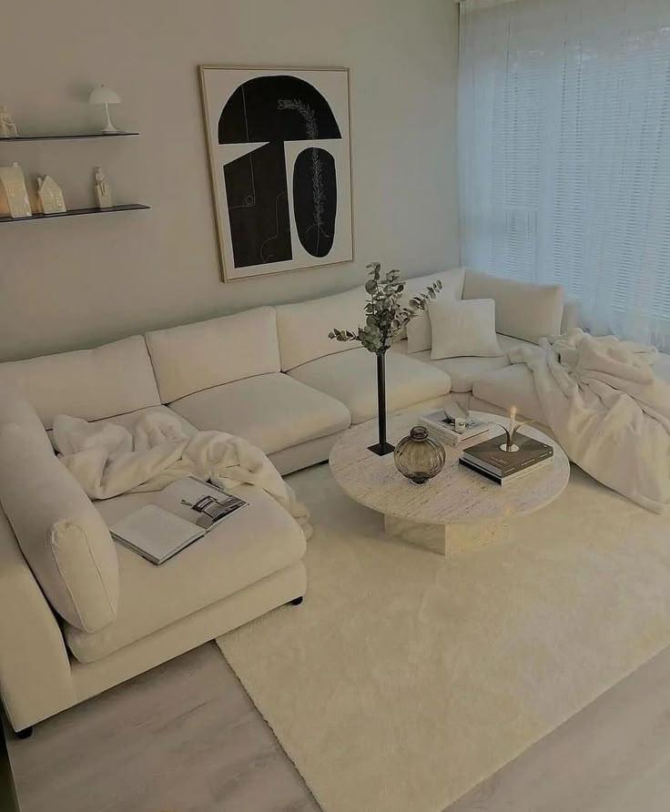 a living room filled with white furniture next to a window