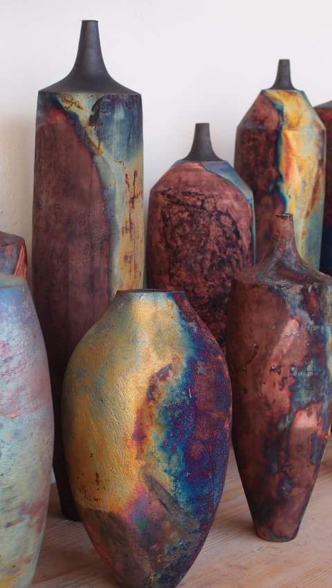 there are many vases that have been painted with different colors and shapes on them