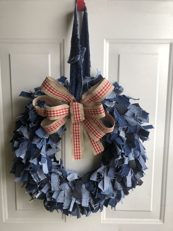 a blue wreath with red and white checkered ribbon hanging on a door handle,