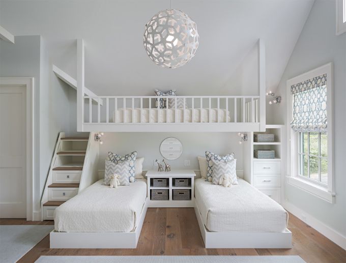 two beds in a room with white walls and wooden floors