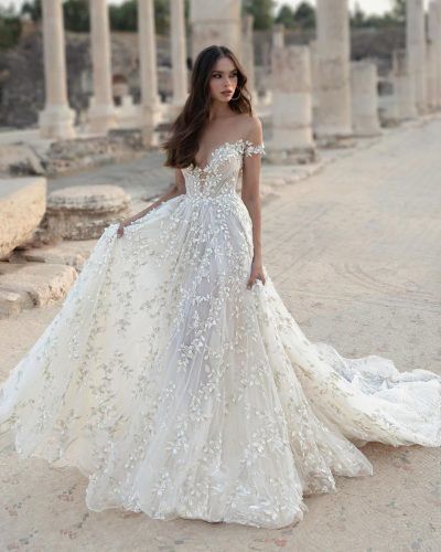 a woman in a wedding dress standing on the side of an old building with columns