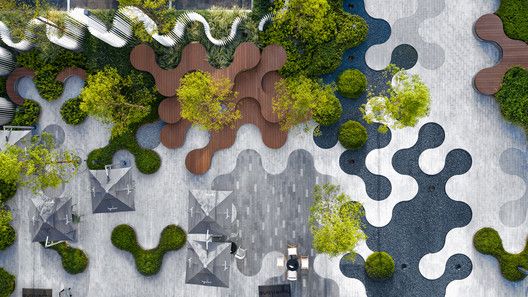 an aerial view of a park with benches, trees and other outdoor seating areas in the area