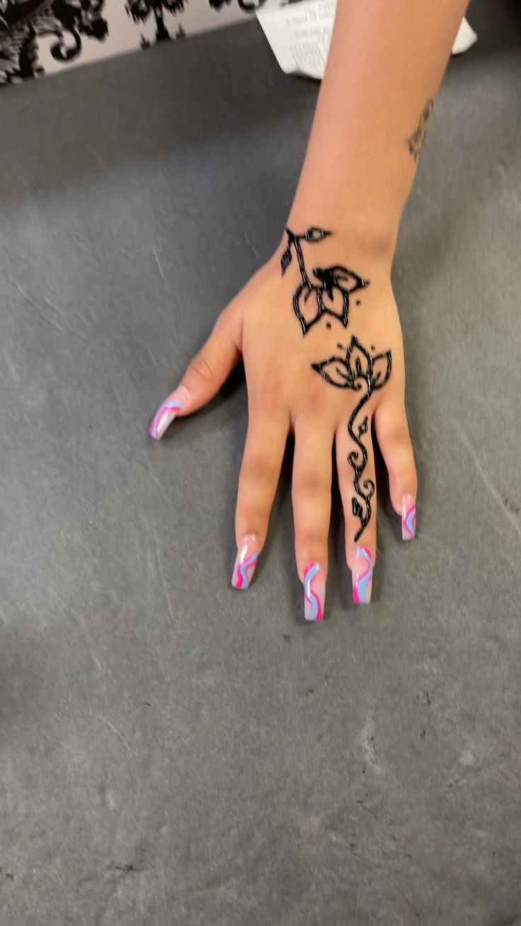 a woman's hand with black and white designs painted on her left palm, resting on the floor