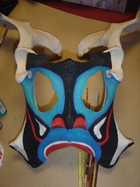 the mask is painted blue, red and white with an animal's face on it