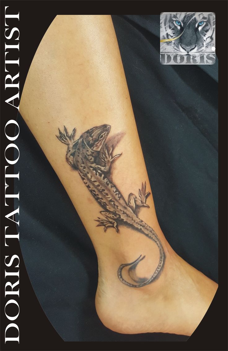 a lizard tattoo on the foot of a person