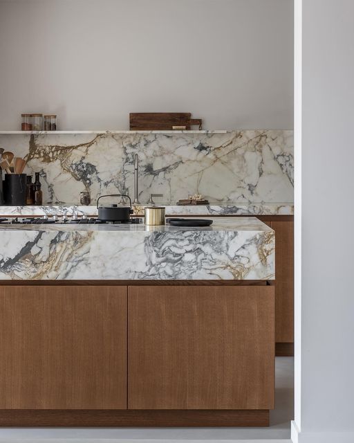 a kitchen with marble counter tops and wooden cabinets