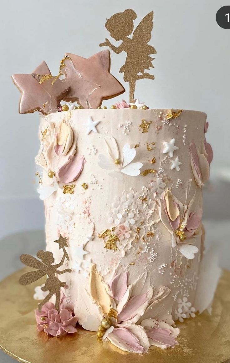 a white cake with pink and gold decorations