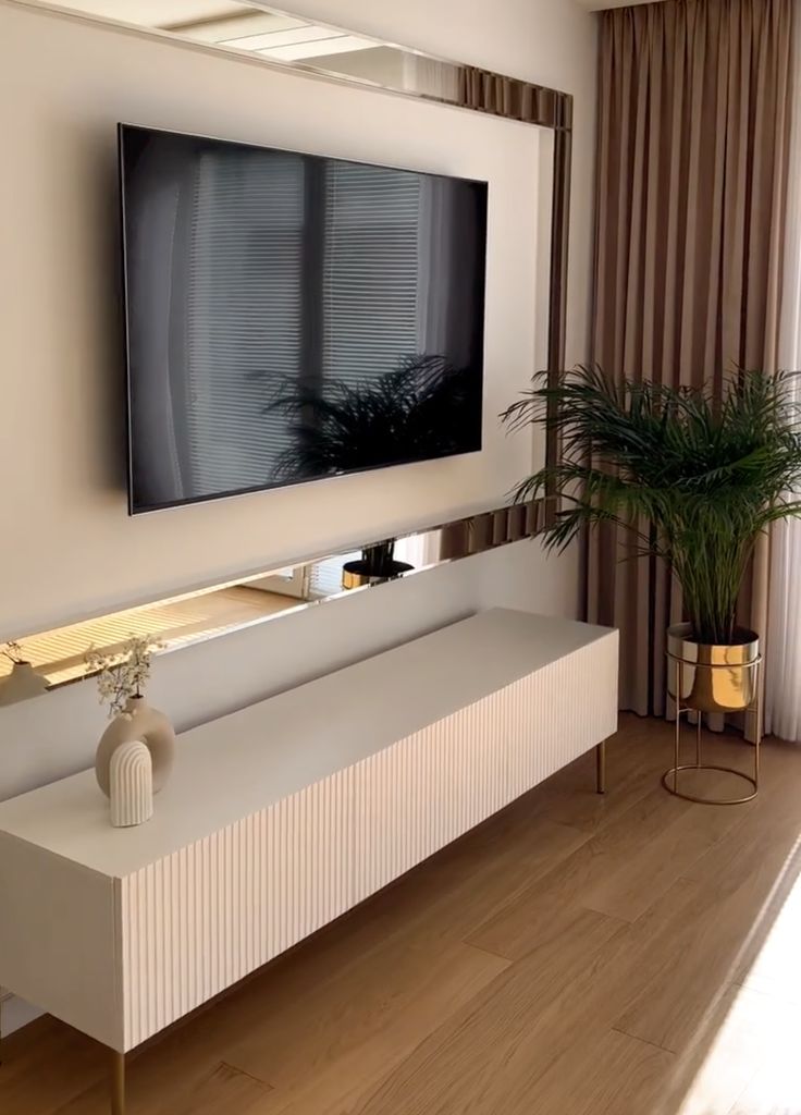 a large flat screen tv mounted to the side of a wall in a living room