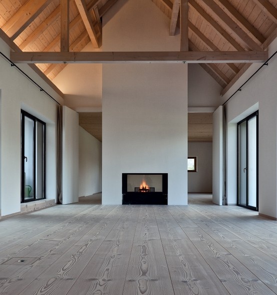 an empty room with wood floors and a fire place