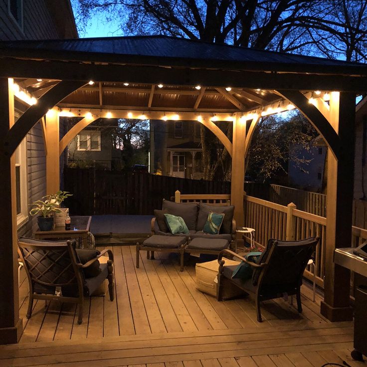 an outdoor covered patio with chairs and lights