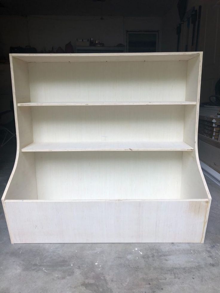 an empty bookcase in a garage with no one around it and the shelves missing