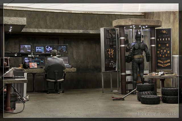 a man sitting at a desk in front of a display with tires on the floor