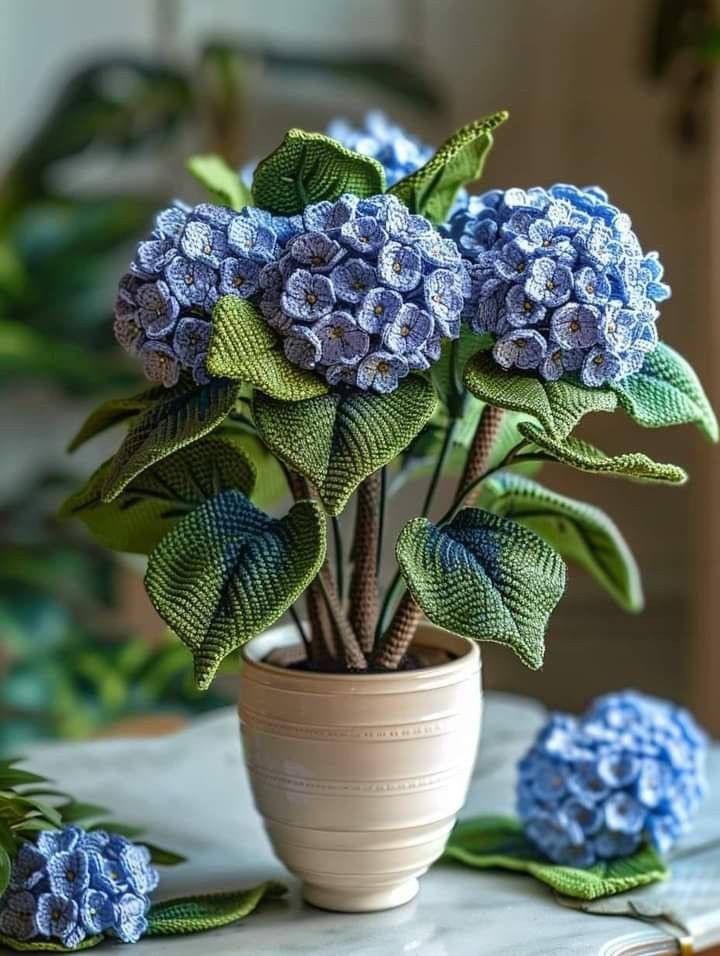 a potted plant with blue flowers sitting on a table