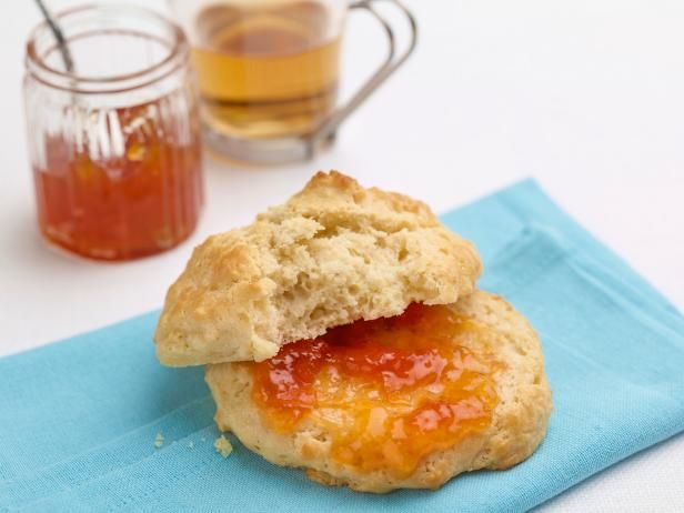 a close up of a biscuit on a blue napkin with jam in the background