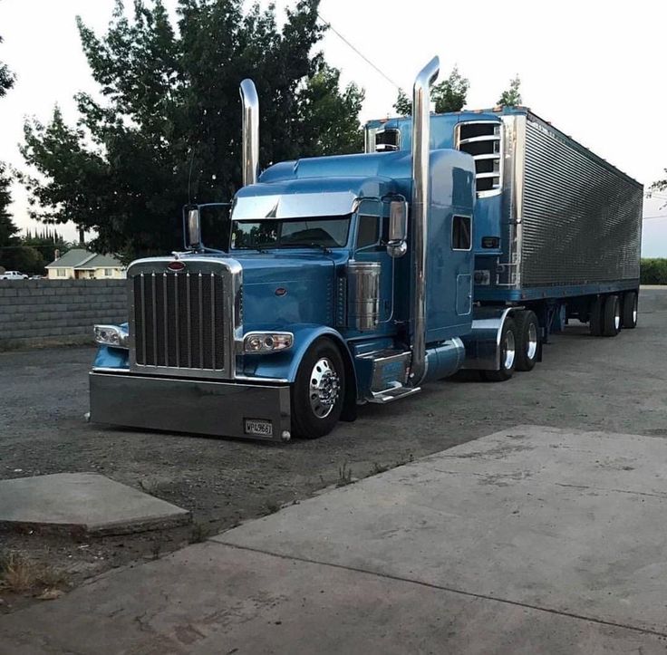 a blue semi truck parked in a parking lot