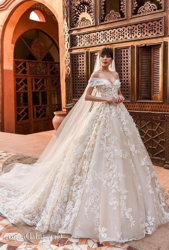 a woman in a wedding dress standing on a tiled floor next to an ornate building