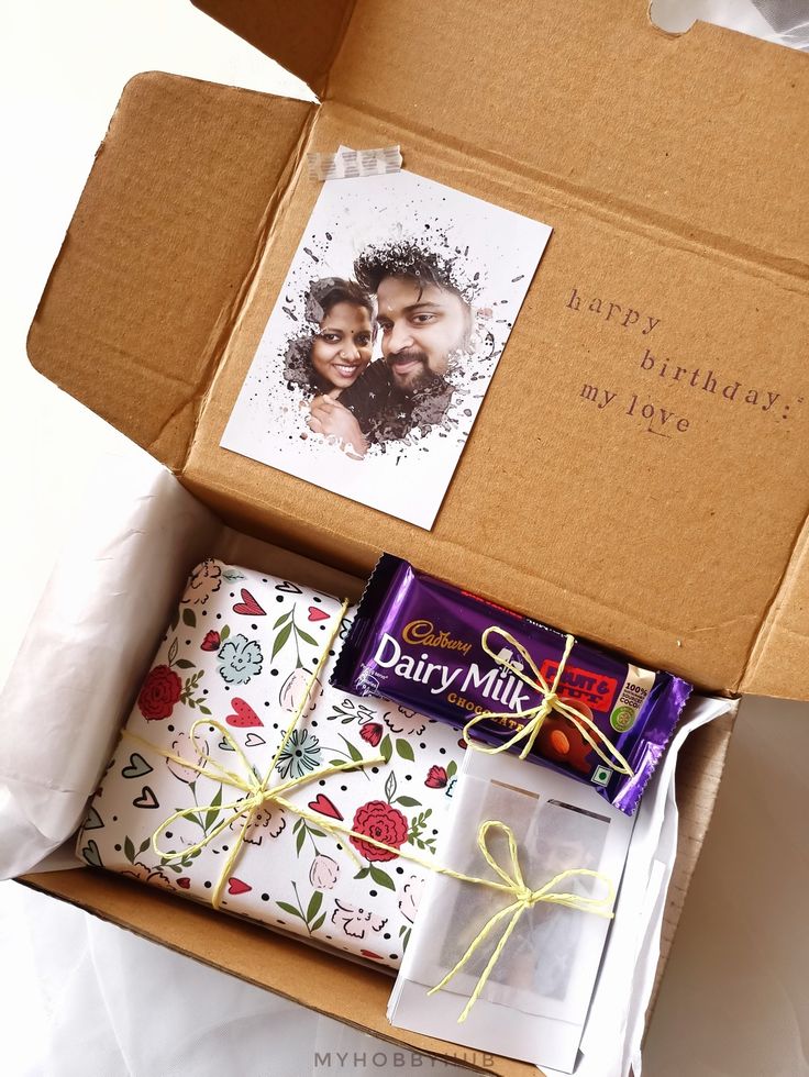 an open box with some wrapping paper and a couple's photo on the inside