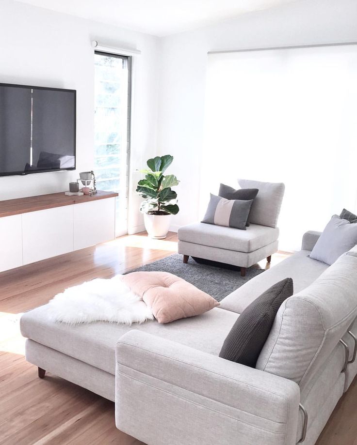 a living room filled with furniture and a flat screen tv mounted to the side of a wall