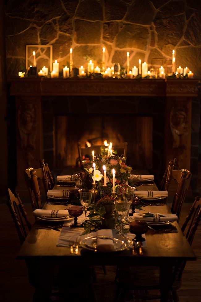 a dining room table set with candles and place settings