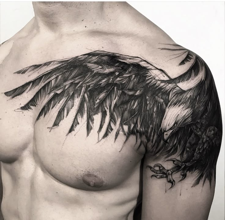 a black and white photo of a man's chest with an eagle tattoo on it