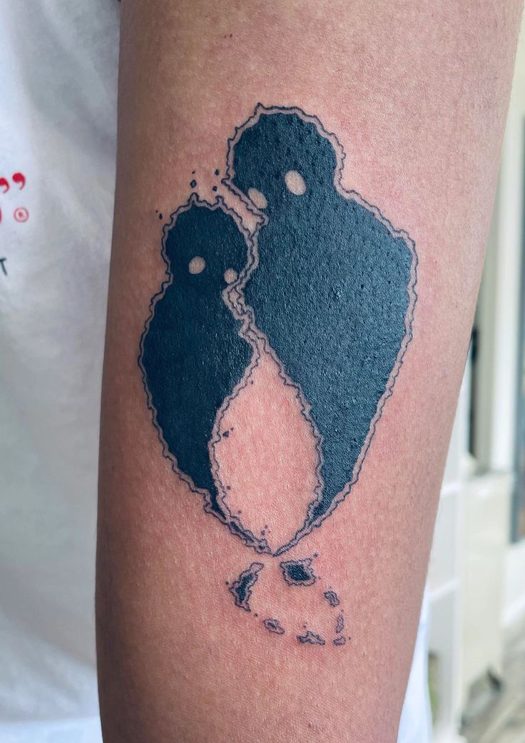 a couple kissing each other on the back of a man's arm with ink