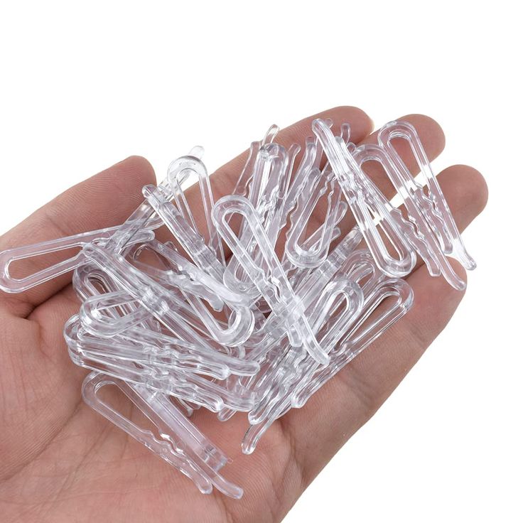 small clear plastic clips are held in a hand