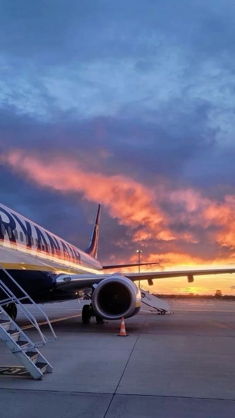 an airplane sitting on the tarmac at sunset with stairs leading up to it's door