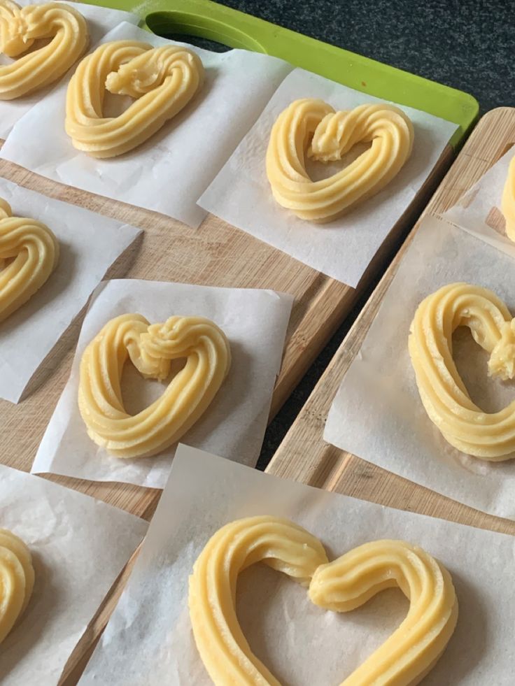 some heart shaped pretzels are sitting on wax paper and ready to be baked