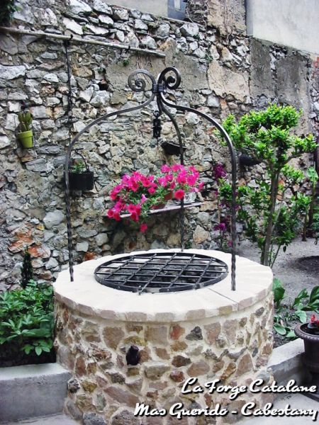 an outdoor fire pit surrounded by plants and flowers