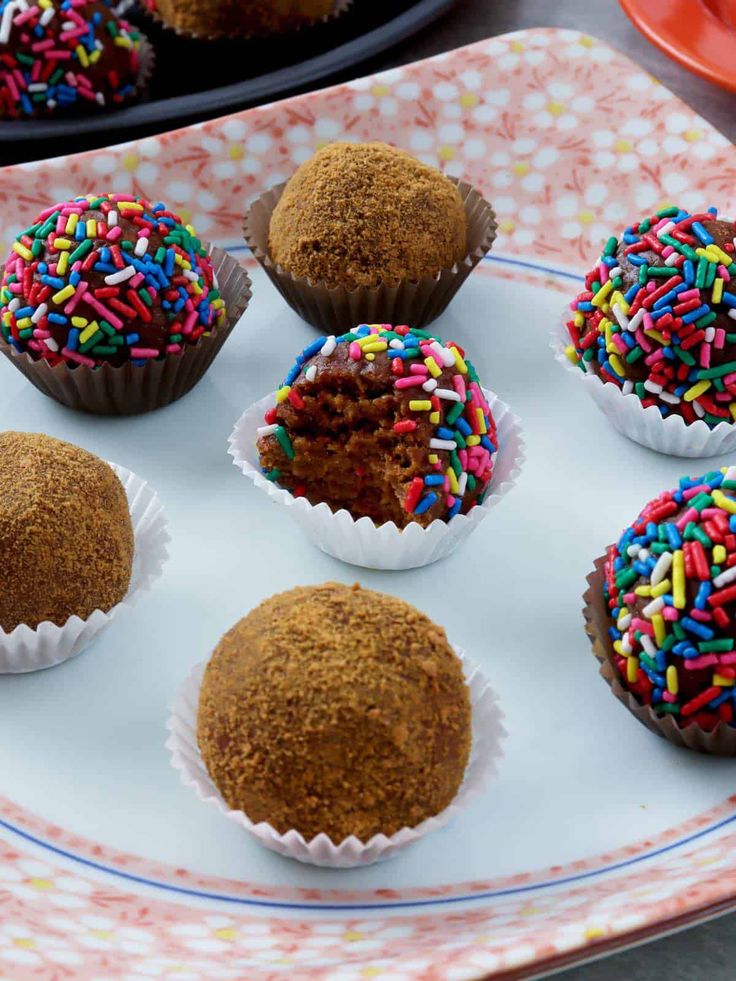 chocolate cupcakes with colorful sprinkles on a white and pink plate