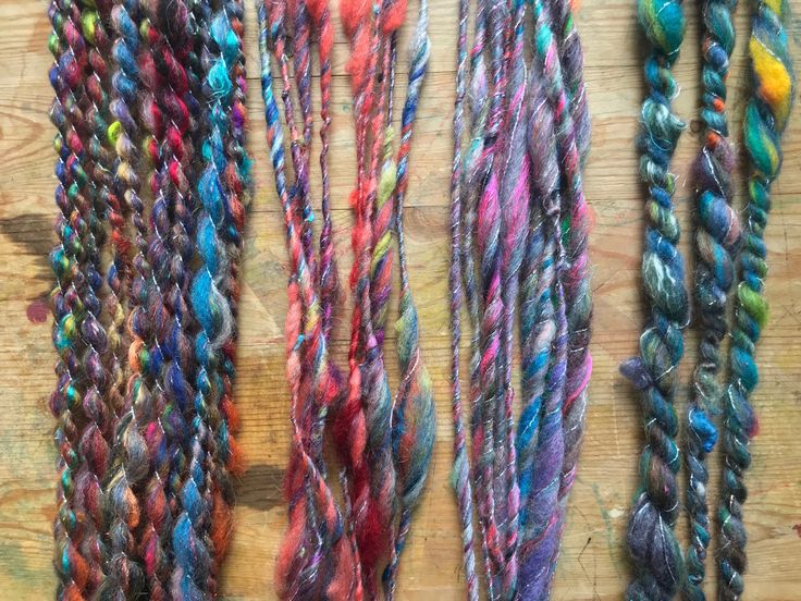 multicolored yarns are laid out on a wooden surface and ready to be dyed